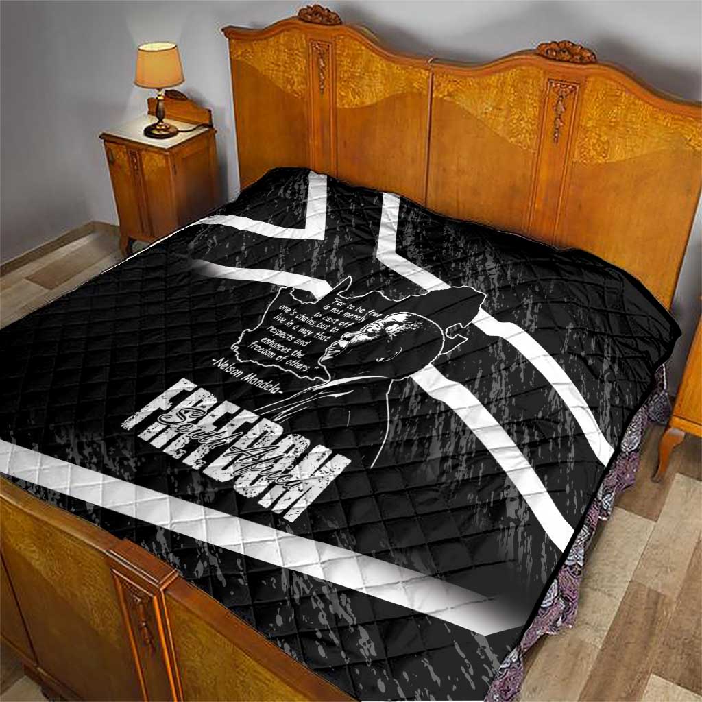Black quilt on bed with white diagonal stripes and Mandela portrait graphic
