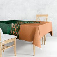 Custom cricket tablecloth with green Celtic panel and orange border, draped on table.