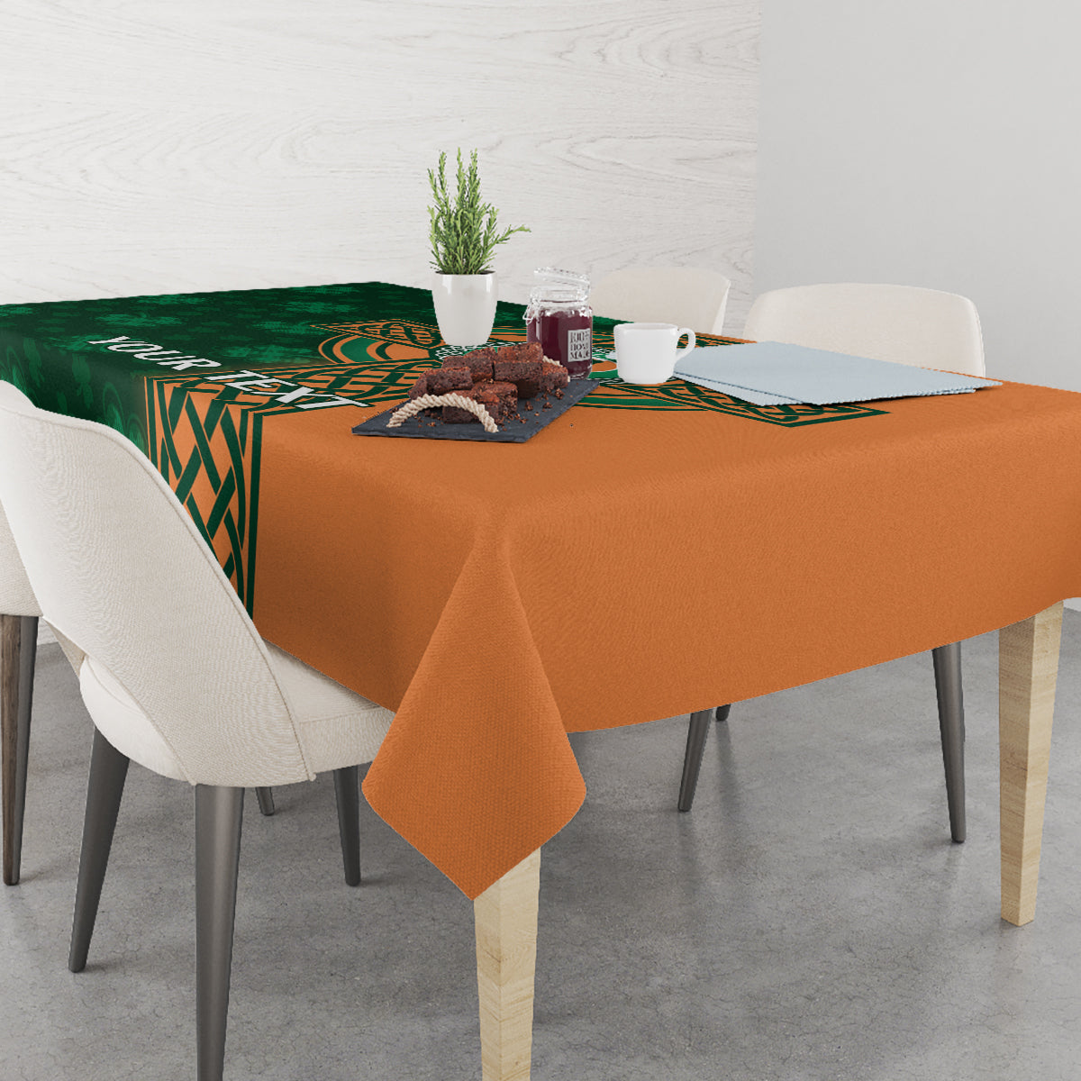 Custom cricket tablecloth with green center Celtic design and orange border on table.