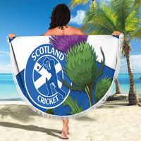 Round beach blanket on sand with Scotland Cricket logo, purple thistle, fringe