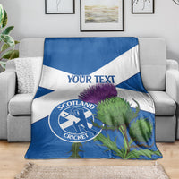 Blue and white Scotland cricket blanket on sofa with thistle print and 'YOUR TEXT'