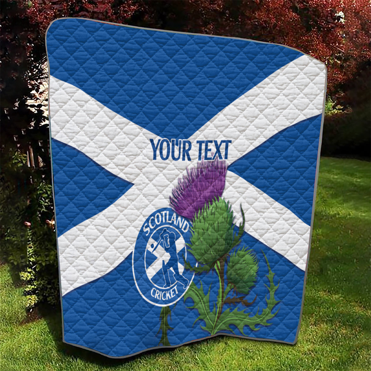 Blue and white Scotland cricket quilt with thistle graphic and Scotland Cricket round emblem.