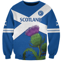 Blue crewneck sweatshirt with white diagonal flag, Scotland crest, purple thistle graphic