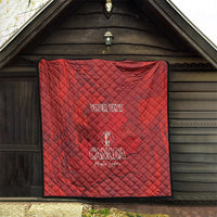 Red quilt blanket with custom text and Canada emblem, hanging on outdoor wooden wall