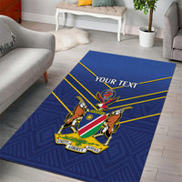 Blue cricket area rug with crest and 'YOUR TEXT' banner, under living room seating