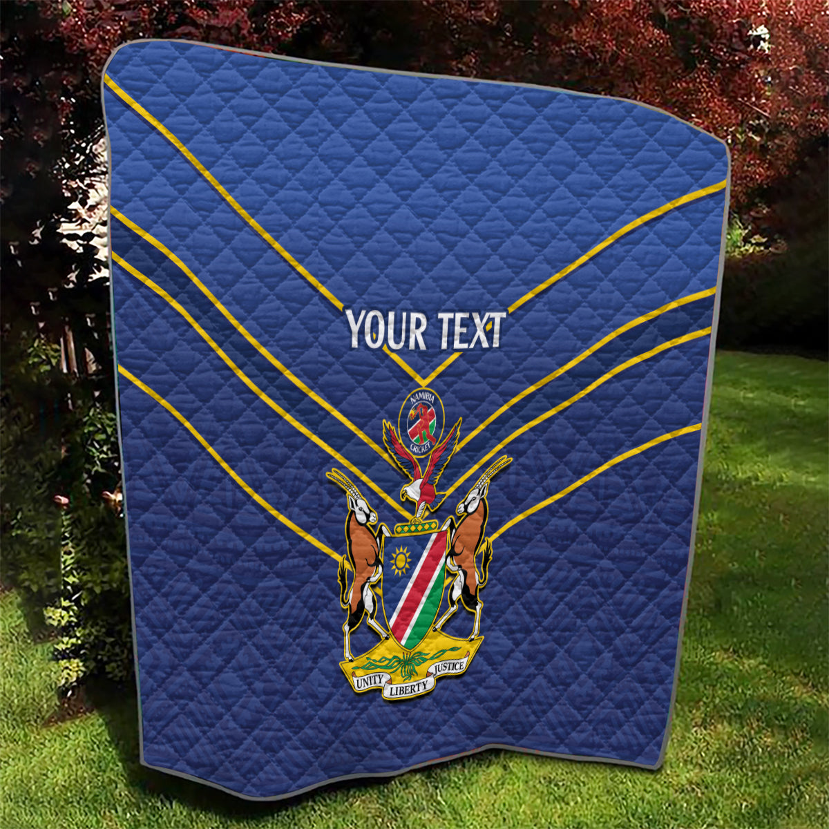 Blue quilt with yellow diagonal stripes and crest emblem, “YOUR TEXT” centered