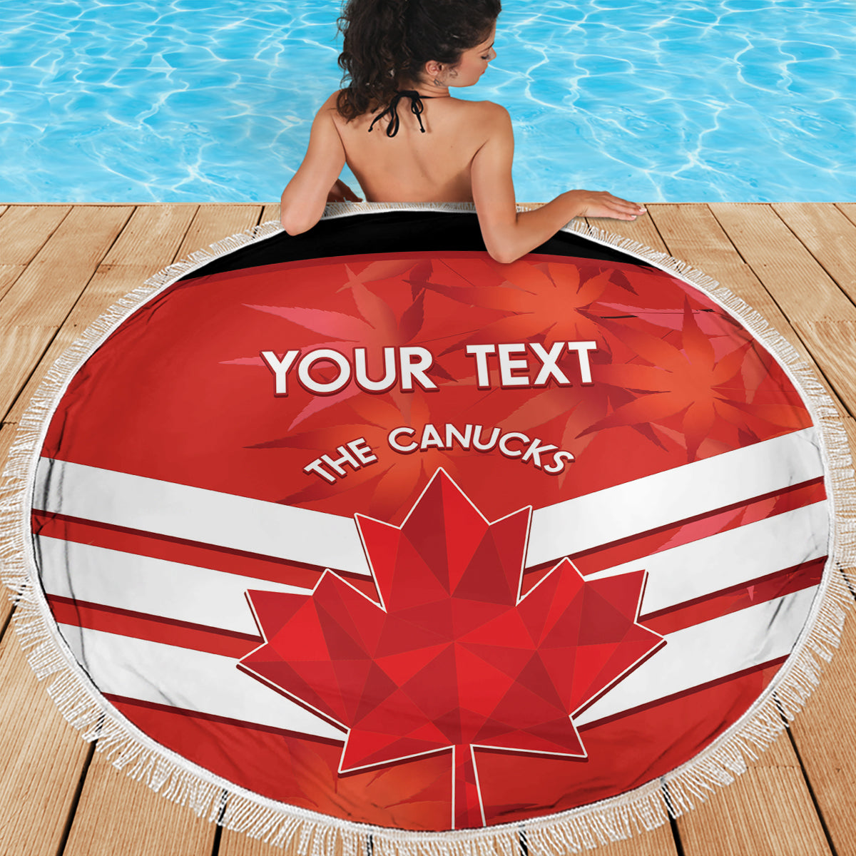 Round beach blanket laid on wooden deck, red-white Canadian flag with maple leaf and fringe
