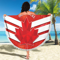 Round beach blanket waved on sandy beach, red-white Canadian flag with maple leaf and fringe