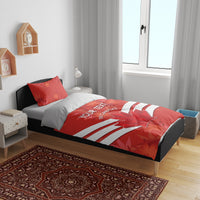 Red bedding set with duvet design of maple leaf and white stripes, two red accent pillows