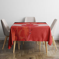 Red tablecloth on dining table with vertical white stripes and custom text header.