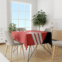 Red tablecloth on dining set with white diagonal stripes, draping over tabletop.