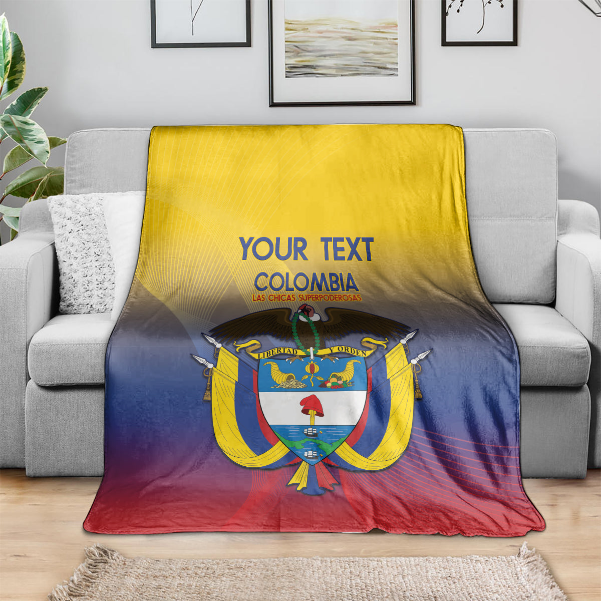 Football blanket draped on a sofa: Colombia crest in yellow-blue-red with 'YOUR TEXT'.