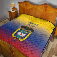 Yellow, blue, and red Colombia quilt laid on a bed with crest and “YOUR TEXT”.