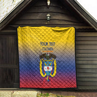 Yellow, blue, and red quilt with Colombia crest and “YOUR TEXT” hanging outdoors.