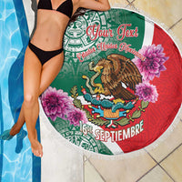 Round beach blanket with green/red eagle emblem, pink flowers, and white fringed edge