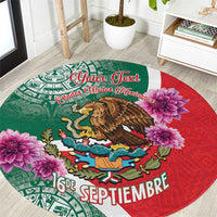 Round decorative carpet with green and red Aztec-style patterns, eagle, and pink flowers