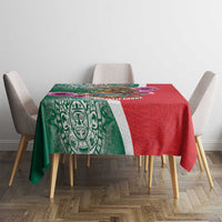Green and red tablecloth with bold Aztec-style center motif and patterned stripe