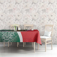 Green and red patterned tablecloth with Aztec-style border on dining table