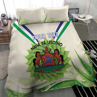 Ivory bedding set with green aloe leaves, custom text, and Lesotho coat of arms on duvet