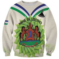 Unisex ivory crewneck sweatshirt with front Lesotho-style coat of arms graphic
