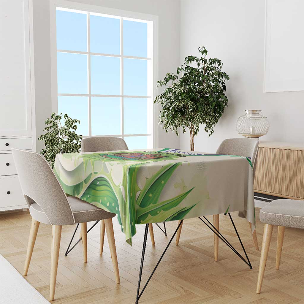 Ivory tablecloth with green aloe leaf artwork, draped on a dining table