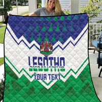 Personalised quilt held up on a patio with blue top, white middle, green bottom