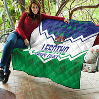 Personalised quilt held outdoors, featuring blue-and-white zigzags and green lower panel