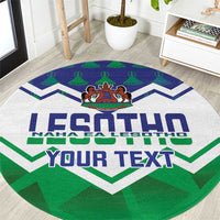 Round green rug close-up with big LESOTHO lettering, zigzag chevrons and emblem