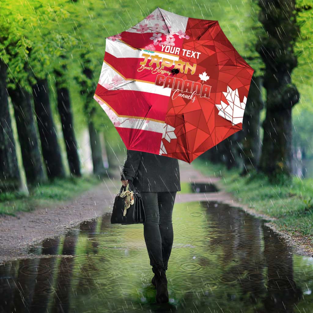 Red custom umbrella with Canada flag stripes and cherry blossom graphic, in wet park