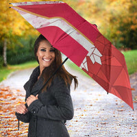 Red custom umbrella with geometric maple leaf print and cherry blossom accents, outdoors