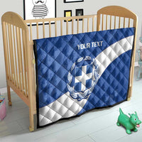 Blue and white quilt in crib with Greece crest and 'YOUR TEXT' text