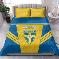Blue-and-yellow bedding set with Sweden crest and custom text on duvet, two yellow pillows.