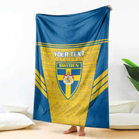 Blue and yellow Sweden football blanket with custom text and crest, hanging over sofa