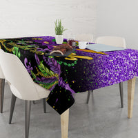 Purple Mardi Gras tablecloth over dining table with fleur-de-lis and feather artwork on dark base