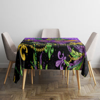 Purple Mardi Gras tablecloth on tabletop with purple glitter texture and fleur-de-lis motifs