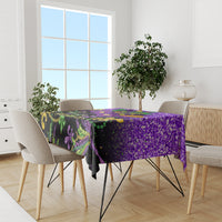 Purple Mardi Gras tablecloth on dining table with dark base and feathered carnival designs
