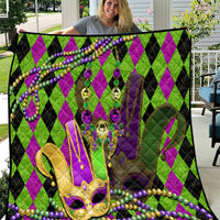 Mardi Gras jester mask quilt with purple and green diamond pattern and dangling bead rows