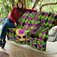 Mardi Gras jester mask quilt held up, purple and green diamonds with bead garland accents
