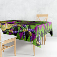 Colorful Mardi Gras tablecloth with jester mask design, green and purple beads, and diamond pattern
