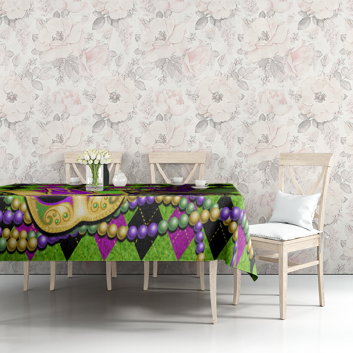 Colorful Mardi Gras tablecloth on table with jester mask, green and purple bead garlands and scallop trim