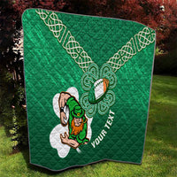 Green quilt blanket with white Celtic knot pattern, shamrock rugby character, and diagonal lettering.