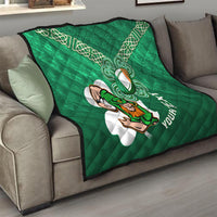 Green quilt on a sofa with white Celtic knots, shamrock rugby mascot, and diagonal text design.
