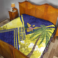 Quilt draped on a bed with blue, yellow, and white stripes; eagle emblem and palm leaves.