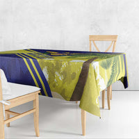 Blue, yellow, and green tablecloth with palm-leaf print, draped on wooden table