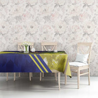 Blue, yellow, and green tablecloth with palm leaves and striped border on dining set