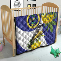 Blue and white baby quilt with bird print, banana-yellow leaves, and circular seal
