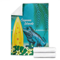 Turquoise tropical blanket with blue iguana, palm leaves, flowers, and 'Cayman Islands' text