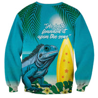 Turquoise crewneck sweatshirt with back iguana and quote text beside surfboard graphic