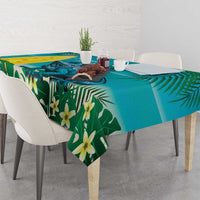 Turquoise and green tropical leaf tablecloth with yellow flower accents on dining table
