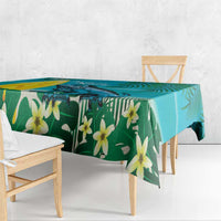Turquoise tropical tablecloth with green foliage and yellow flowers, draped on table